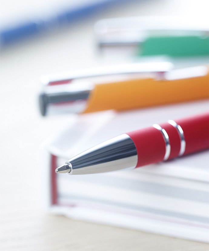 Eri värisiä metallikyniä kirjan päällä